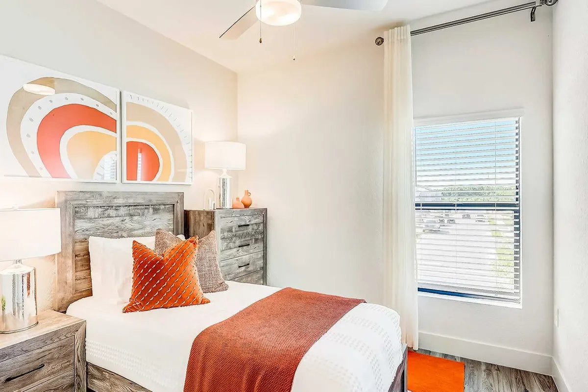Bedroom with a window, a ceiling fan and a grey wood headboard