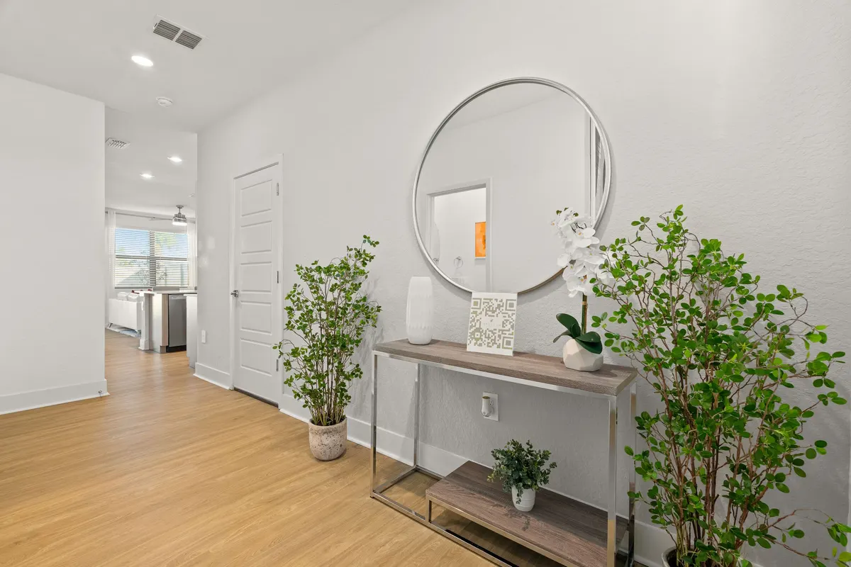 Entry hall with a console table, mirror and plants