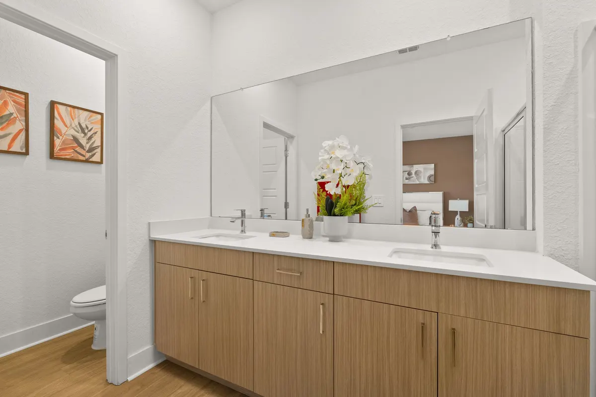 Primary bathroom with a double vanity and a large mirror