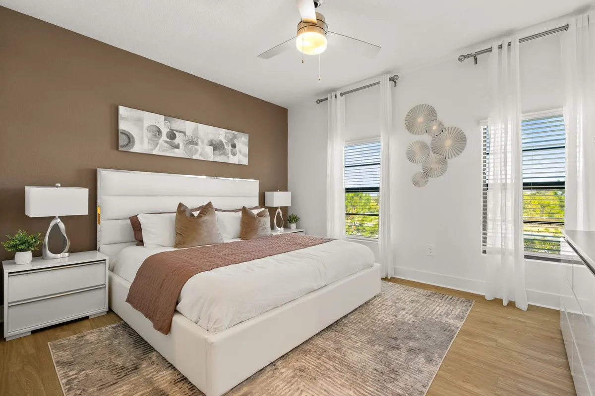 Primary bedroom with a king bed, an accent wall and two windows