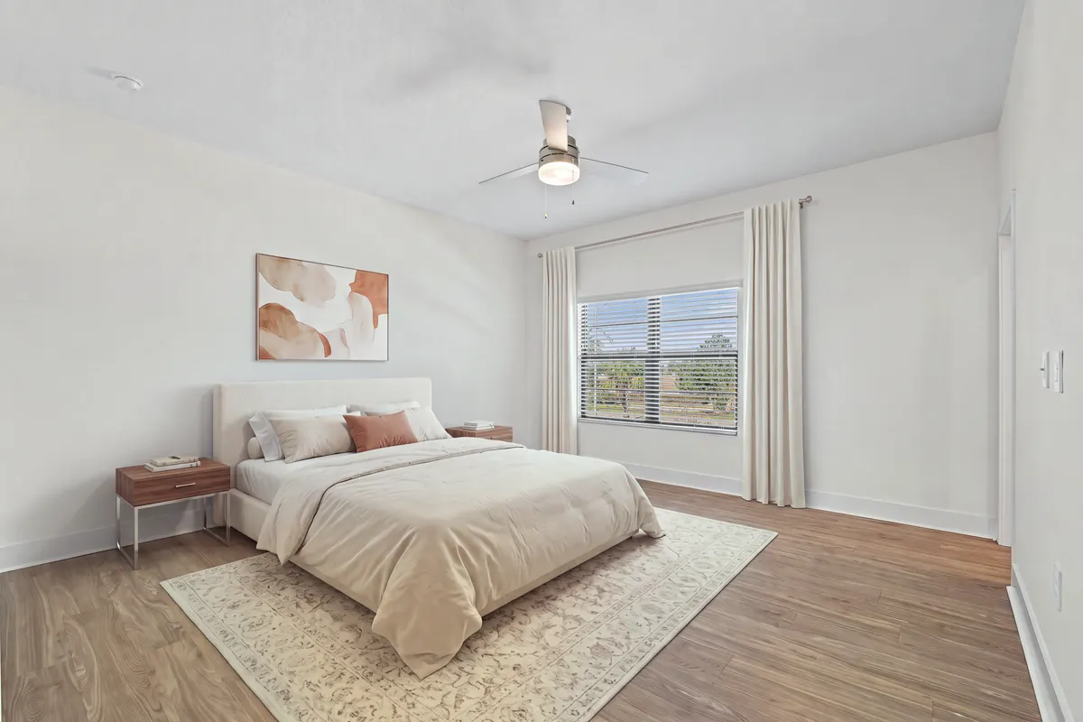 Amber bedroom with a bed, two nightstands, a rug and curtains around the window. Virtually staged.